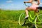 Young woman back on bicycle cruiser in nature.