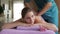 Young woman on back massage session at spa salon.
