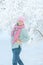A young woman on the background of a beautiful plant in the snow. A young lady laughs merrily in a snowfall. Great mood
