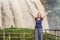 Young woman on the background of Majestic landscape of Elephant waterfall in summer at Lam Province, Dalat, Vietnam