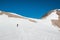 A young woman with backpack and pole hiking on iceberg and snow and enjoying the views of the Andes mountains and lake