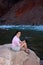 Young woman backpacker resting by Hance Rapids in the Grand Canyon.