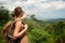 Young woman with backpacker standing on top of the mountain and