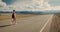 Young woman backpacker walking on road.