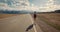 Young woman backpacker walking on road.