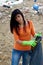 Young woman with bag full of dirt on destroyed dirty beach