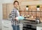 Young woman with baking sheet of cookies near oven