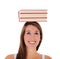 Young woman balancing books on her head