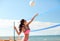 Young woman with ball playing volleyball on beach