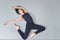 Young woman ballerina lying and stretching on the floor at ballet studio, view from above.