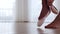 Young woman ballerina puts on her pointe shoes