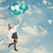 Young Woman with Balloons against Blue Cloudy Sky