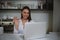 A young woman at the bar communicates behind the monitor, smiles and waves her hand