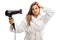 Young woman in a bathrobe blowdrying her hair