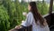 Young woman in bathrobe waking at morning and having breakfast on balcony at hotel room. Concept of people traveling