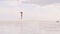 Young woman in beach bikini jumping and dancing on white sand. Happy woman enjoying summer day on sandy island and sea