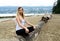 Young woman at the beach of Stanley Park on log, her arms are do