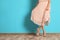 Young woman with beautiful long legs in stylish outfit near color wall, closeup