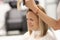 Young woman beauty salon client makes haircut at hairdresser