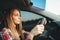 Young woman beginner driving a car, back view