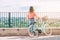 Young woman with a bicycle contemplates a beautiful landscape