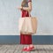 Young woman with big eco bag by shopper on hand. Copy space
