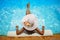 Young woman in big white hat rested on a lounger in the pool