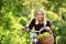 Young woman with bike in green park.