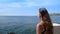 Young woman in a bikini comes out on the balcony to enjoy the open sea