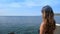 Young woman in a bikini comes out on the balcony to enjoy the open sea