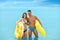 Young woman in bikini and her boyfriend with inflatable toys. Lovely couple