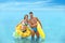 Young woman in bikini and her boyfriend with inflatable toys. Lovely couple