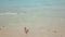 Young woman in bikini lying on sand at sea beach droneview. Happy woman tanning on summer beach, sea waves and sand