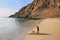 Young woman in bikini sitting at La Mina Beach in Paracas Nation