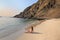 Young woman in bikini sitting at La Mina Beach in Paracas Nation