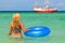 Young woman in bikini standing backwards in sea water with swimming circle