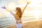 Young woman in bikini swimsuit posing relax in tropical sea beach with arms raised