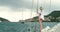 Young woman in bikini on a yacht enjoying the view of an Italian village in the distance. Woman in a bikini sailing on a