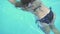 Young woman in black bikini swimming in resort hotel pool. Beautiful woman relaxing in swimming pool at summer holiday