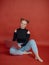 young woman in a black blouse with buns hairstyle sits with a laptop against. university student. freelance. distant work