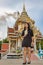 Young woman in black dress standing in front of crematorium in Buddhist monastery