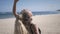 Young woman in black shine dress standing on beach