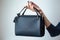 Young woman with black small handbag with perfect dark violet manicure