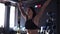 Young woman in black sportswear performs squats with a barbell in the gym on the background of the interior of a fitness