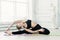 young woman in black sportswear shows yoga asanas and does pilates