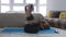 Young woman blogger shoots video doing Yoga exercise with phone while Maine Coon cat is sitting side by side at home