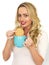 Young Woman With Blonde Hair Relaxing and Dunking a Biscuit in a Mug of Tea