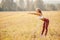 Young woman blonde in red pants and white T-shirt performs warm before running in park