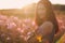 Young woman on blooming flower field. Femininity concept.