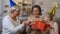 Young woman blowing birthday candle, receiving presents from loving family